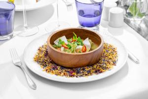 un bol de nourriture sur une assiette sur une table dans l'établissement Palácio Estoril Hotel, Golf & Wellness, à Cascais