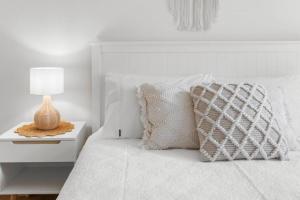 Dormitorio blanco con cama con lámpara en mesita de noche en Seymour Cottage in Victor Harbour, en Victor Harbor