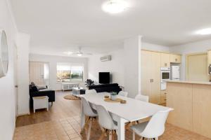 a kitchen and living room with a white table and chairs at Seymour Cottage in Victor Harbour in Victor Harbor