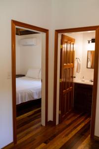 a bedroom with a bed and a bathroom with a mirror at Crystal Creek Lodge in Orange Walk