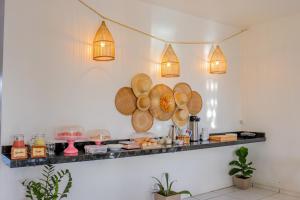 a counter with plates and lights on a wall at Pousada Farol da Barra in Tutóia