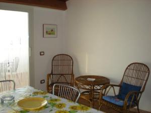 een eetkamer met drie stoelen en een tafel en een tafel en een stoeltje bij Casa Adelaide in Santa Croce Camerina
