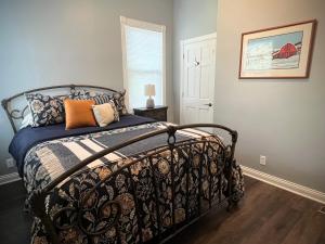 a bedroom with a bed with a black and white comforter at Cozy cottage near downtown Prescott in Prescott