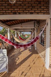 une chaîne de drapeaux rouges et blancs suspendus à une terrasse couverte dans l'établissement Pousada Farol da Barra, à Tutóia