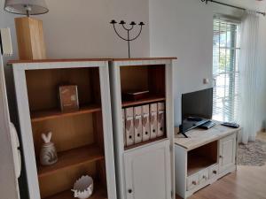 einen weißen Schrank mit einem Computer in einem Zimmer in der Unterkunft Ferienhaus Am Bach in Kirchberg an der Raab