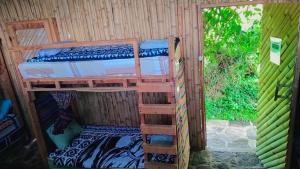 a room with two bunk beds and a window at The Hub - Centro Sakbe in San Juan La Laguna
