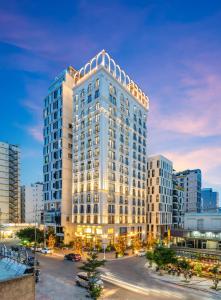 a large white building in a city at night at Golden Lotus Luxury Hotel Danang - Complimentary Daily Afternoon Tea in Danang