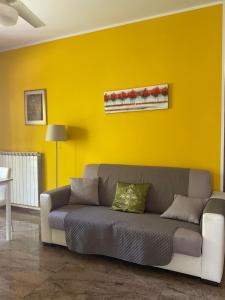 ein Wohnzimmer mit einem Sofa in einer gelben Wand in der Unterkunft CASA FEDERICA in Marghera