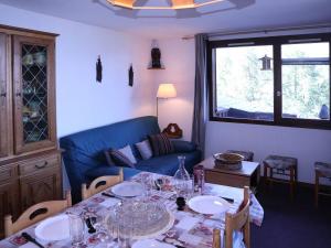 a living room with a table and a blue couch at Appartement Les Orres, 3 pièces, 6 personnes - FR-1-322-532 in Les Orres