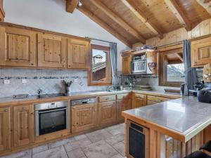 a kitchen with wooden cabinets and a stove top oven at Chalet familial cosy pour 8 pers. près des pistes et commodités à Courchevel Le Praz - FR-1-568-44 in Courchevel +5 photos