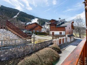 a group of buildings and a stone wall at Chalet familial cosy pour 8 pers. près des pistes et commodités à Courchevel Le Praz - FR-1-568-44 in Courchevel