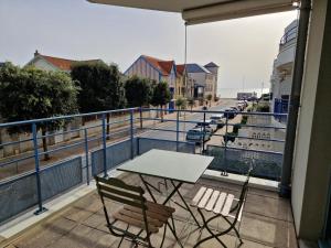 a table and chairs on a balcony with a view of the ocean at Chatelaillon-Plage Centre-Ville: Apt 4 pers, balcon, parking, piscine, wifi - FR-1-706-21 in Châtelaillon-Plage