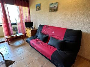 un sofá negro y rojo en la sala de estar en Studio Villard-de-Lans, 1 pièce, 4 personnes - FR-1-515-183, en Villard-de-Lans