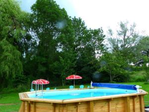 ein Pool mit zwei Sonnenschirmen in der Unterkunft Gîte Louroux-de-Bouble, 5 pièces, 12 personnes - FR-1-489-477 in Louroux-de-Bouble