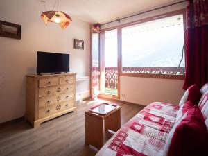 a living room with a tv and a large window at Appartement Valmorel, 2 pièces, 4 personnes - FR-1-291-895 in Valmorel