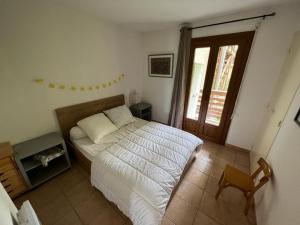 a bedroom with a bed and a chair and a window at Appartement Les Angles, 3 pièces, 6 personnes - FR-1-593-93 in Les Angles