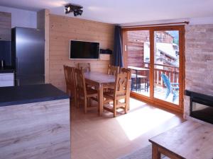 a kitchen and dining room with a table and a television at Appartement Les Orres, 2 pièces, 8 personnes - FR-1-322-533 in Les Orres