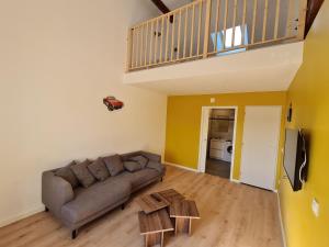 a living room with a couch and a table at Gîte rénové près de Nancy et Metz, animaux admis - FR-1-584-296 in Lironville