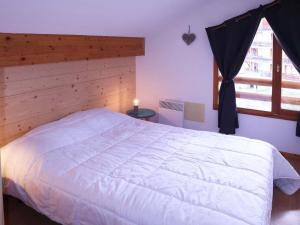 Un dormitorio con una gran cama blanca y una ventana en Appartement Les Orres, 2 pièces, 8 personnes - FR-1-322-533, en Les Orres