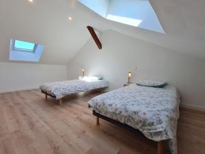 a attic bedroom with two beds and a window at Gîte rénové près de Nancy et Metz, animaux admis - FR-1-584-296 in Lironville