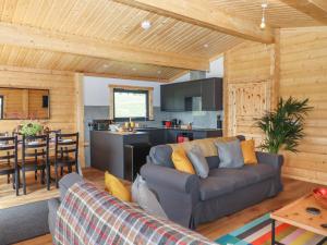 a living room with a couch and a kitchen at Foxglove Lodge in Exeter