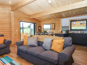 a living room with a couch and a kitchen at Foxglove Lodge in Exeter