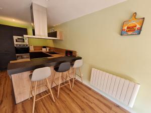 a kitchen with a counter and stools in a room at Gîte rénové près de Nancy et Metz, animaux admis - FR-1-584-296 in Lironville