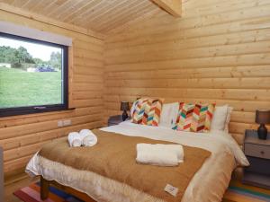 a bedroom with a bed in a log cabin at Foxglove Lodge in Exeter