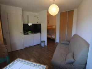 een woonkamer met een bank en een keuken bij Appartement Huez, 1 pièce, 4 personnes - FR-1-405-334 in Huez