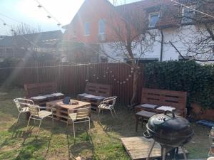 a backyard with a table and chairs and a grill at Buzahouse in Ljubljana