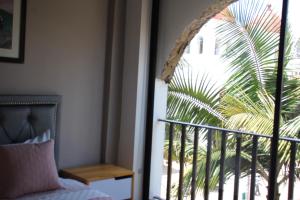 a bedroom with a bed and a palm tree outside a window at Hotel Plaza El Santuario in Santuario