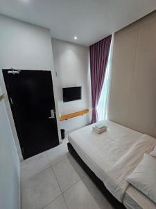 a hotel room with a bed and a television at TT99 COZY STAY in Miri