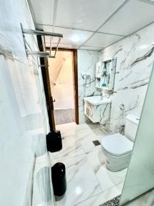 biała łazienka z toaletą i umywalką w obiekcie Mirage Camp Wadi Rum w mieście Wadi Rum