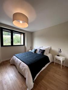 a bedroom with a large bed and a large window at Gîte Bois Tordu - 3 chambres - proche Bourganeuf in Montboucher