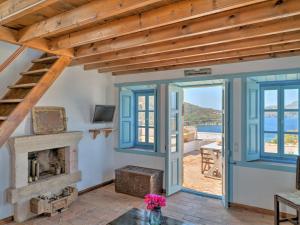 a living room with a fireplace and a wooden ceiling at Eirini Luxury Hotel Villas in Grikos