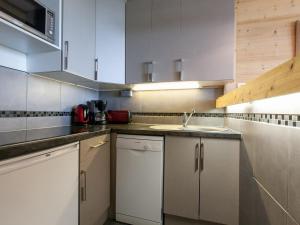 una cocina con armarios blancos y fregadero en Appartement Avoriaz, 2 pièces, 5 personnes - FR-1-314-109, en Morzine