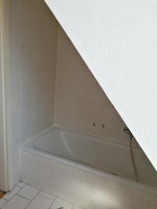 y baño de azulejos blancos con bañera blanca. en Apartment Bonnie, en Pirmasens