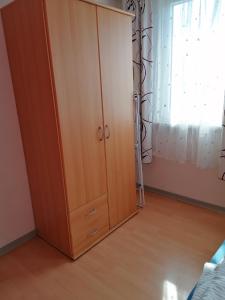 un gran armario de madera en un dormitorio con ventana en Apartment Bonnie, en Pirmasens