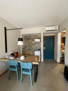 a kitchen with a wooden table and two blue chairs at Resort em pirinopolis in Pirenópolis