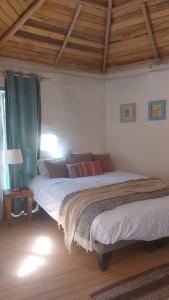 a bedroom with two beds and a wooden ceiling at CasaSutar in San Pedro de Atacama