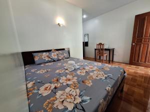 a bedroom with a bed with a blue blanket with flowers at Island Front - Bangcogon Resort and Restaurant in Oslob