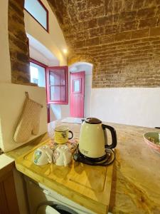 un bollitore per il tè e due tazze su un bancone della cucina di Casa da Moeda a Évora