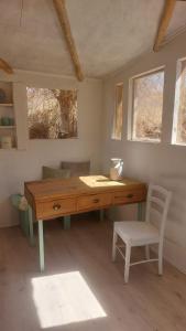 a desk in a room with a chair and two windows at CasaSutar in San Pedro de Atacama