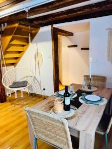 - une table en bois avec des bouteilles de vin et des chaises dans l'établissement S'Hiesele petite maison alsacienne typique, à Ittenheim