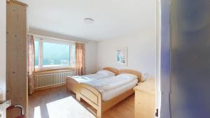 um quarto com uma cama num quarto com uma janela em Haus Leibnitzer em St. Moritz