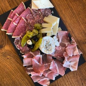 a plate of food with meats and cheese on a table at Camping De La Sarre in Abreschviller