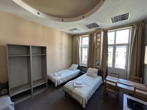 una stanza con due letti, un tavolo e finestre di Studio Kraszewskiego 5 a Rzeszów