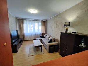 a living room with a couch and a tv at Dwupokojowe mieszkanie Nowy Dwór Mazowiecki in Nowy Dwór Mazowiecki +2 photos