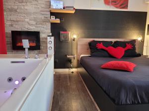 アヴィニョンにあるLove & Spaのベッドルーム1室(ベッド1台、バスタブ、赤いハートピロー付)