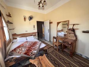 1 dormitorio con cama, silla y espejo en People to People Hostel Siwa en Siwa